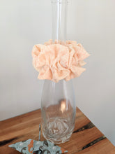Load image into Gallery viewer, creamy colour scrunchie displayed on the bottle