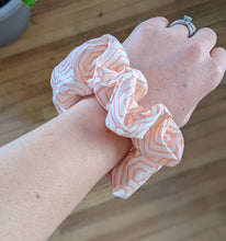 Load image into Gallery viewer, peachy orange hexagon geometric pattern scrunchie on the wrist
