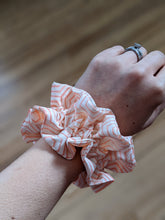 Load image into Gallery viewer, Orange line scrunchie on the wrist
