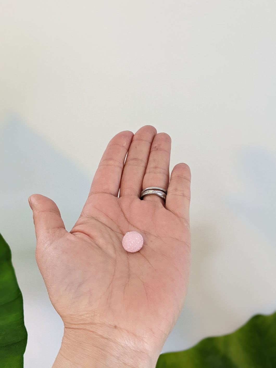 pink earring on a palm